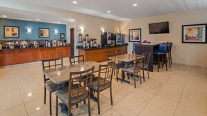 A hotel dining area with a buffet, a bar, and a TV mounted on the wall. - Best Western Gas City (Gas City)