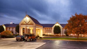 A hotel with a prominent entrance, a parking lot, and a large tree. - Best Western Gas City (Gas City)