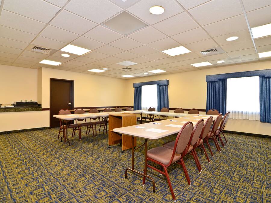 Un salón de conferencias con una larga mesa, sillas y un atril.