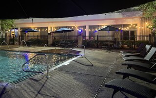 Una piscina al aire libre, sombrillas, sillones reclinables de piscina