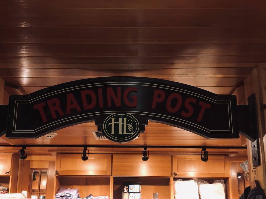 A wooden interior with a sign reading "TRADING POST" and a logo with "HL".