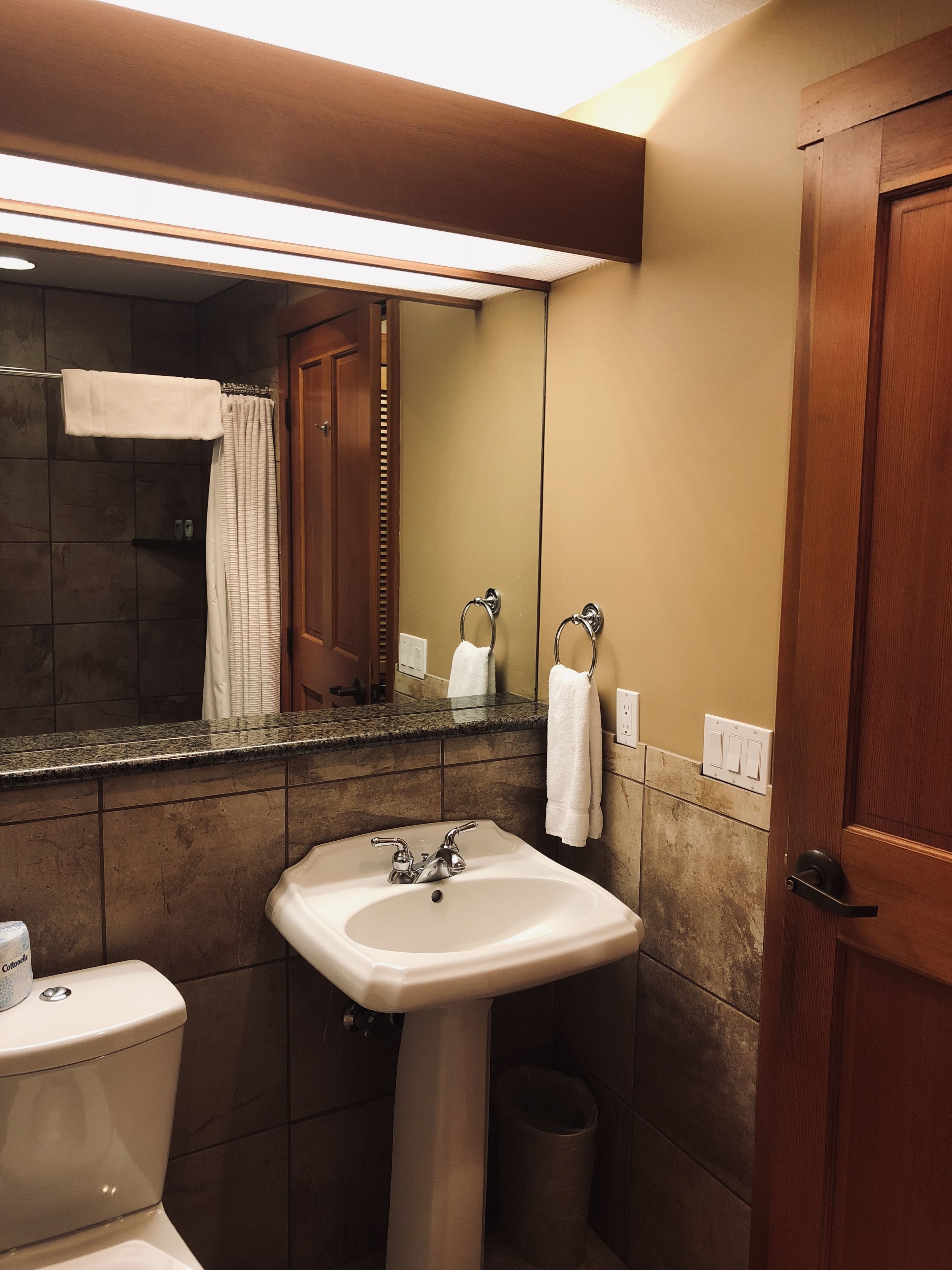 A bathroom with a sink, toilet, and shower area.