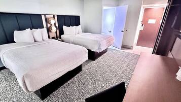 Escritorio, cortinas blackout y tabla de planchar con plancha