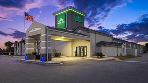 A hotel with a modern design, a flag, and a sign indicating it's a Wyndham hotel.