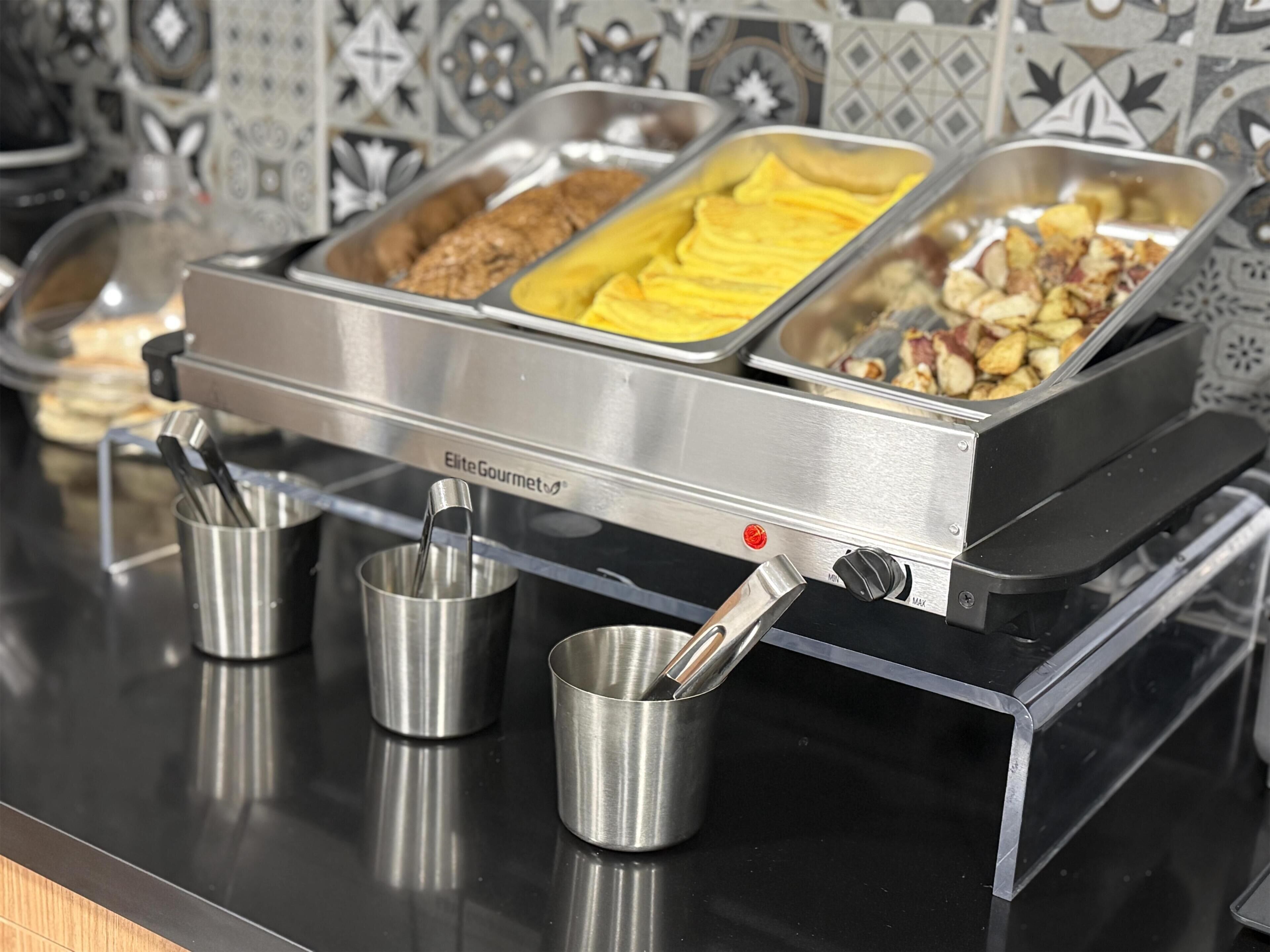 A buffet setup with various food items and utensils.