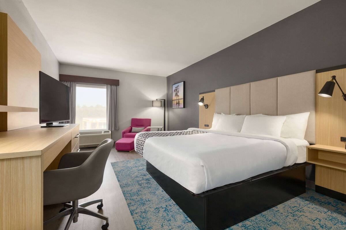 Une chambre d’hôtel équipée d’un lit, d’un bureau, d’une chaise et d’un téléviseur.