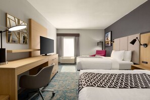 A hotel room with a desk, two beds, a TV, and a large window with curtains. - La Quinta Inn & Suites by Wyndham Selma/Smithfield I-95 (Selma)