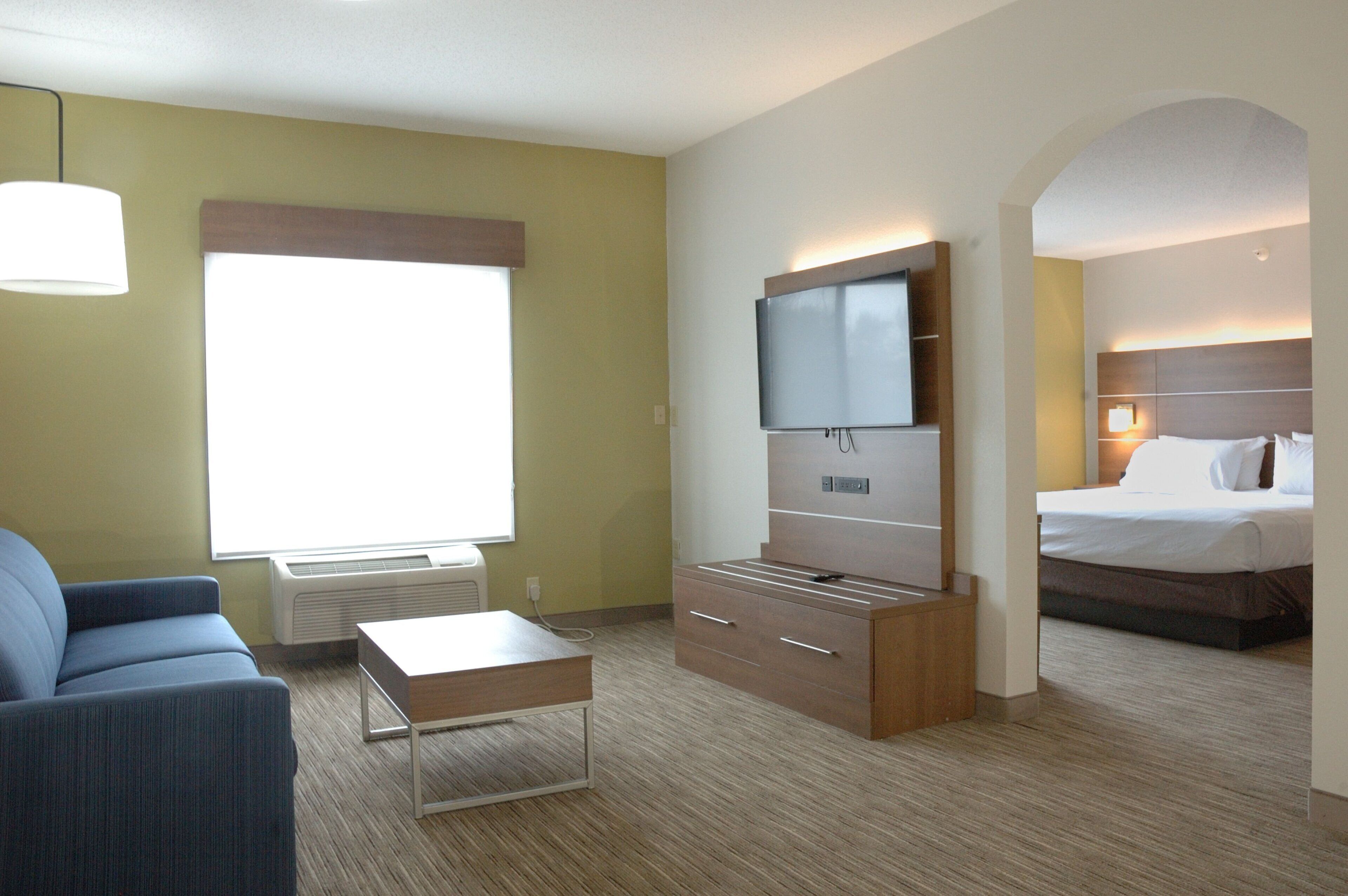 Una habitación de hotel con cama, televisión, escritorio y sofá.