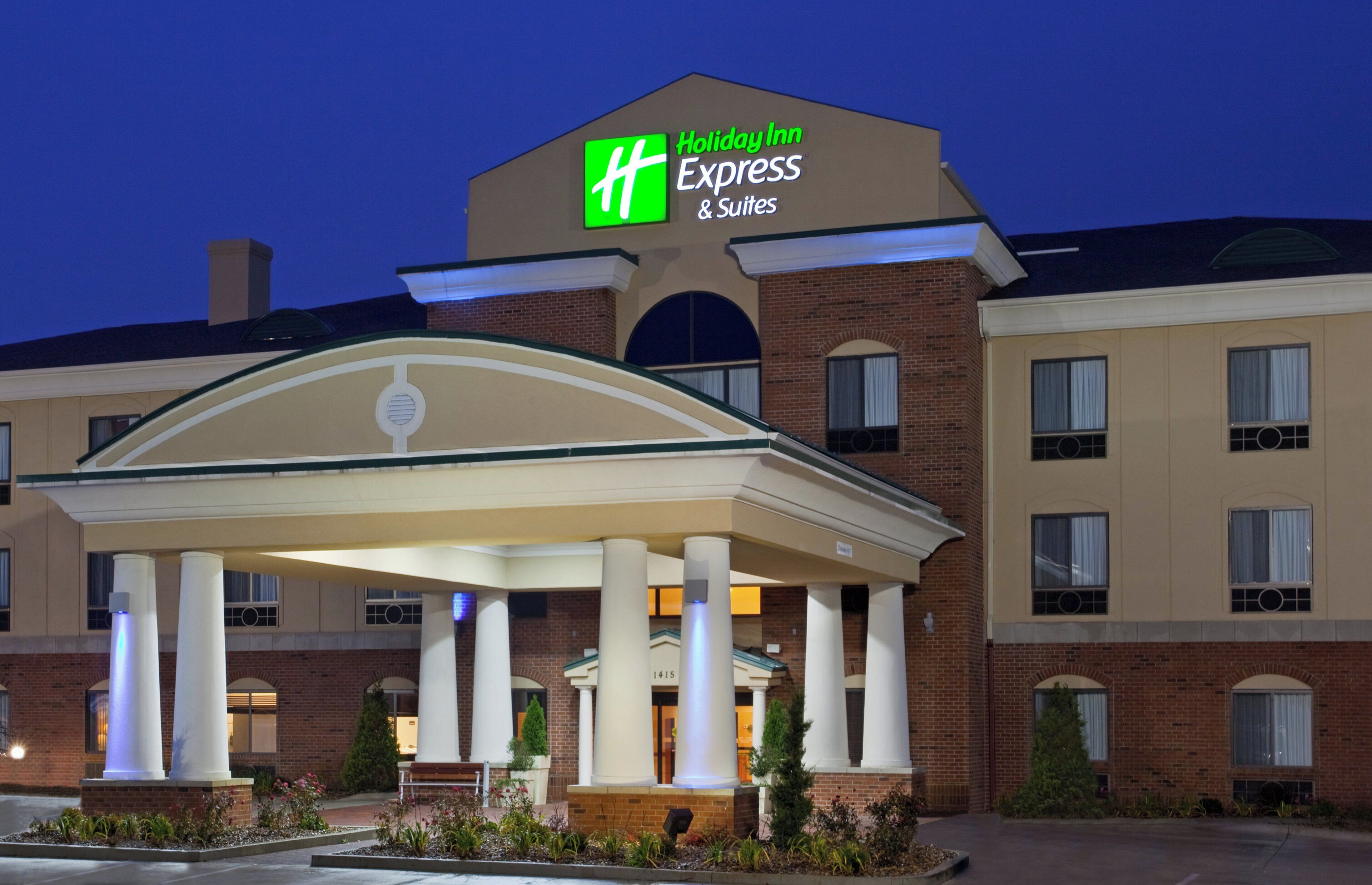 A Holiday Inn Express & Suites hotel with a covered entrance and brick facade.