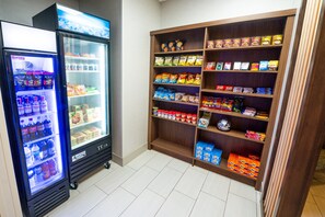 A vending machine and a snack shelf in a room. - Holiday Inn Express Hotel & Suites Goshen by IHG (Goshen)
