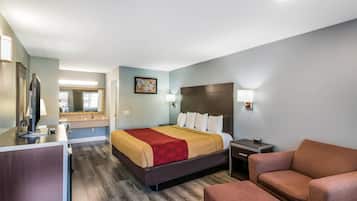 Une chambre d’hôtel équipée d’un lit, d’une table de chevet, d’une lampe et d’un téléviseur.