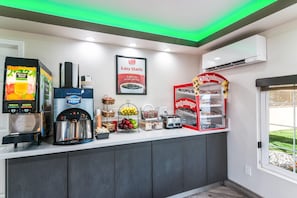 A self-service breakfast area with a coffee machine, a juice dispenser, and a toaster. - Econo Lodge Hesperia - Victorville I-15 (Hesperia)
