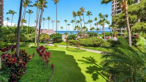 A resort with a well-maintained lawn, palm trees, and a view of the ocean. - Kaanapali Alii-2 Bedroom Ocean Views (Lahaina)