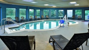 A pool area with a diving board, lounge chairs, and a view of the outdoors. - Holiday Inn Express Lewisburg/New Columbia by IHG (New Columbia)