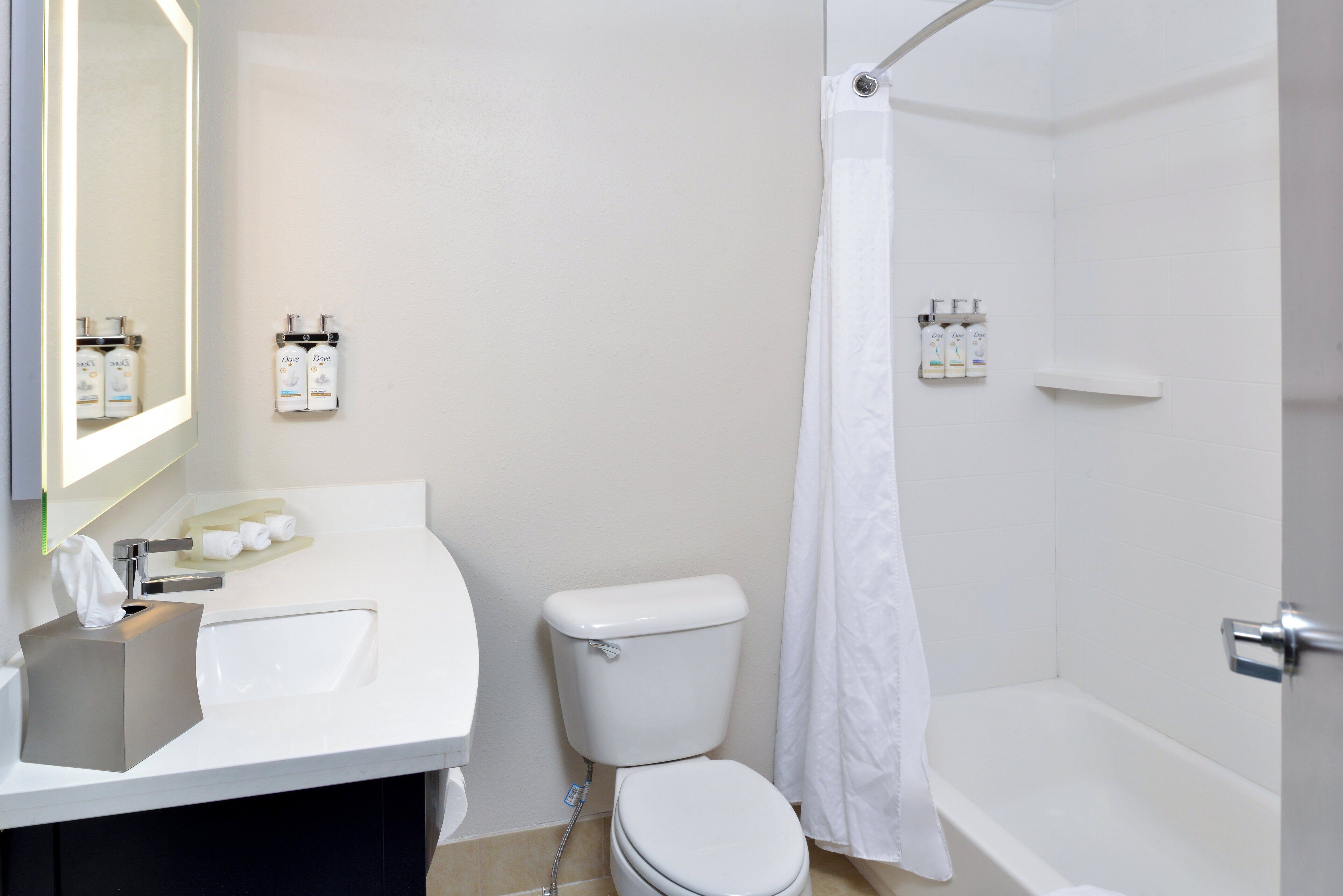 A bathroom with a toilet, sink, and shower.