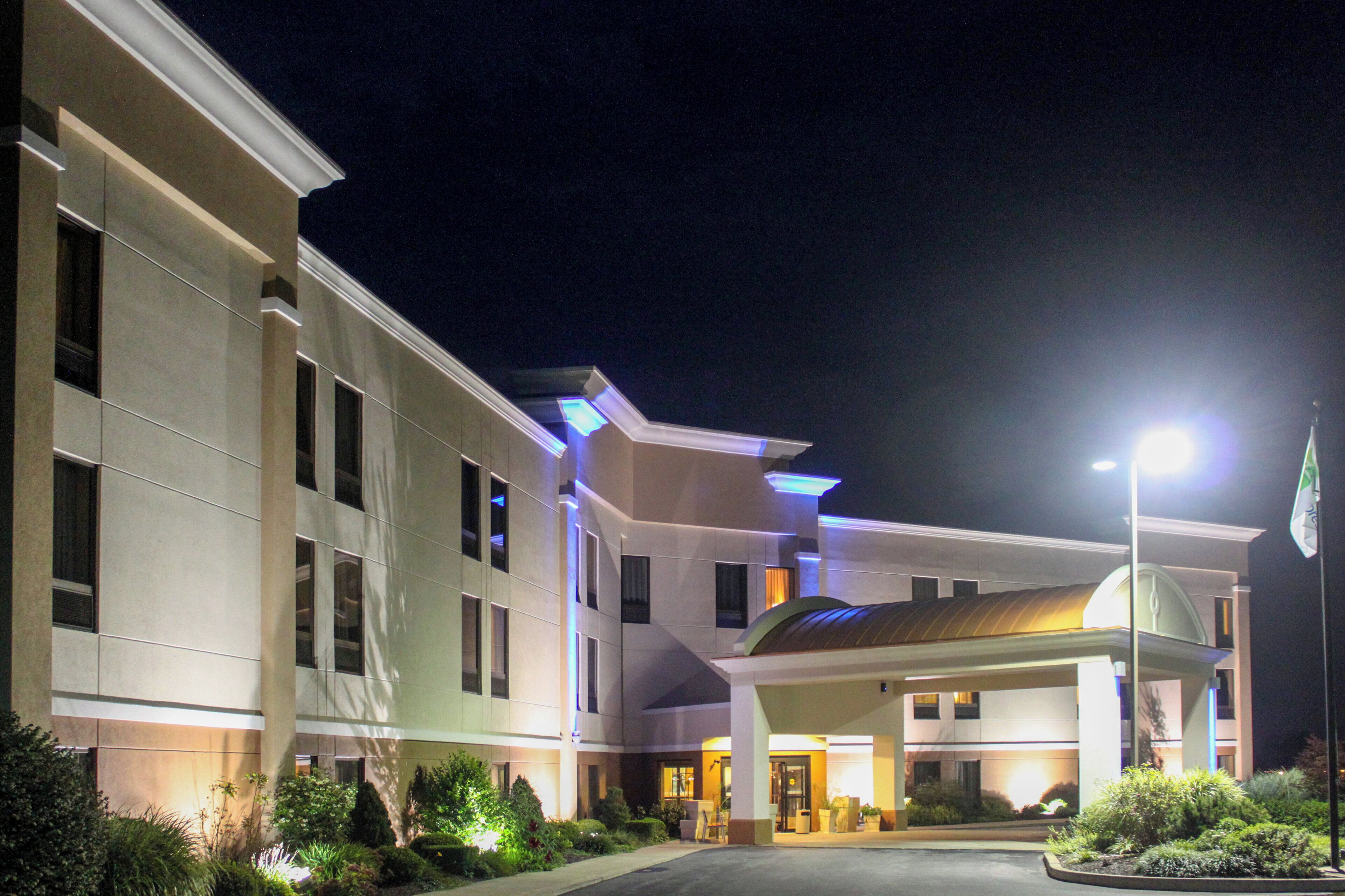 A multi-story hotel with a covered entrance and a flagpole.
