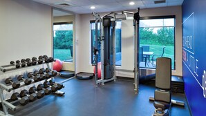 A gym with exercise equipment, a red exercise ball, and a view of the outdoors through large windows. - Holiday Inn Express Lewisburg/New Columbia by IHG (New Columbia)