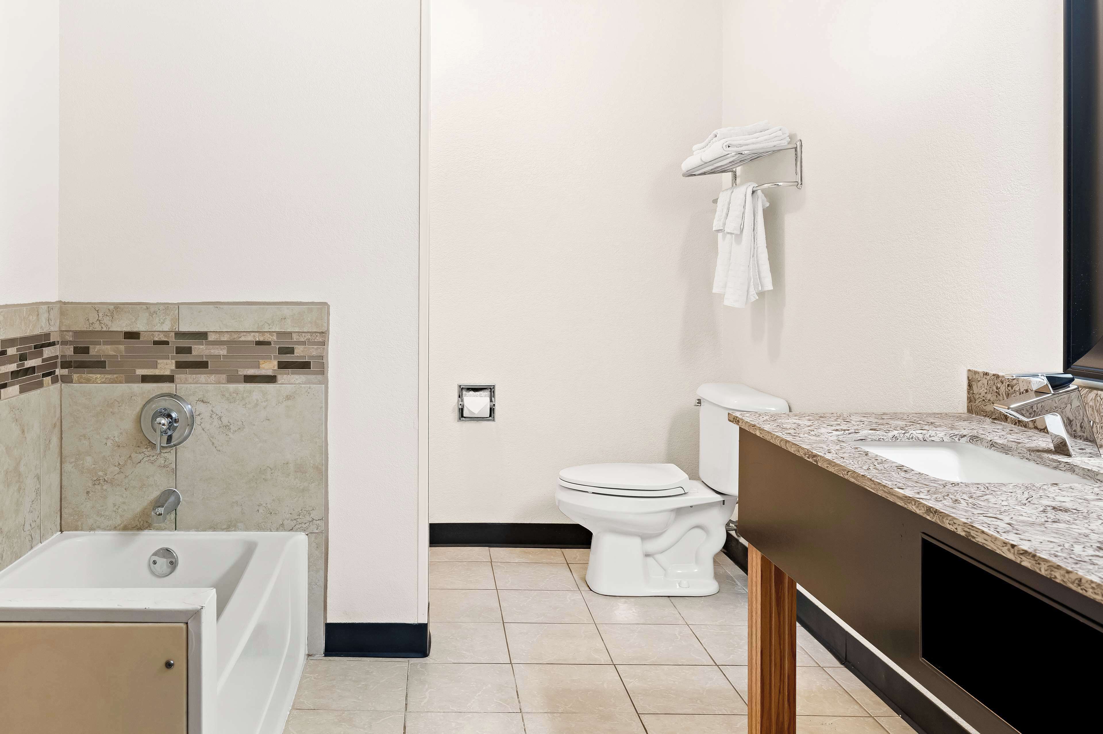 Ein modernes Badezimmer mit Badewanne, Toilette und Waschtisch.