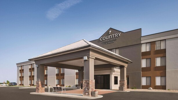 A Country Inn & Suites building with a covered entrance, multiple floors, and a parking lot.