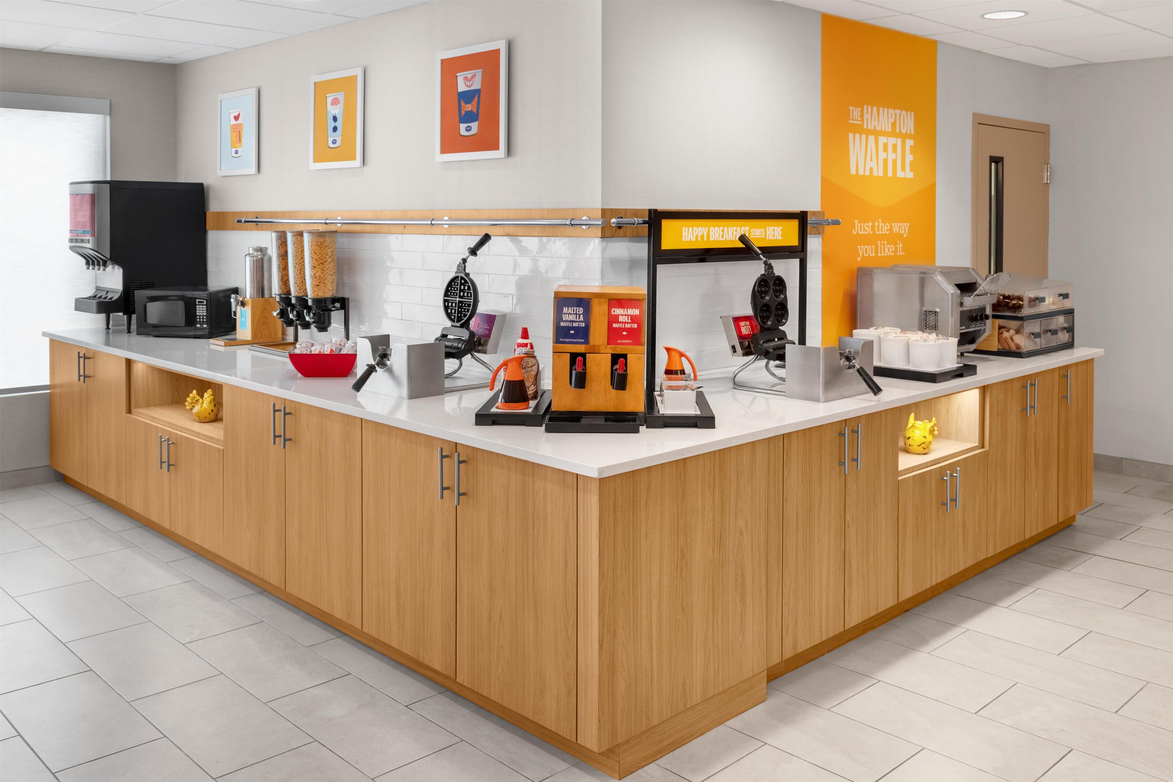 Un área de cocina moderna con cafetera, máquina para hacer gofres y diversos electrodomésticos.