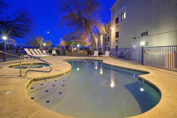 Una piscina al aire libre, sillones reclinables de piscina
