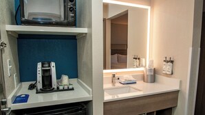 A hotel bathroom with a coffee maker, sink, and mirror. - Holiday Inn Express Airport - Tucson by IHG (Tucson)