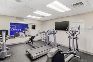A fitness center with treadmills, elliptical machines, and weight machines.