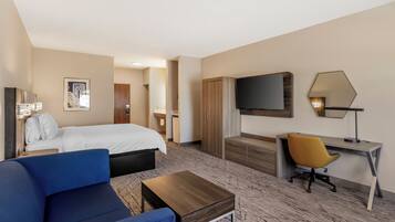 Une chambre d’hôtel avec un lit, un bureau, une chaise, une télévision et une lampe.