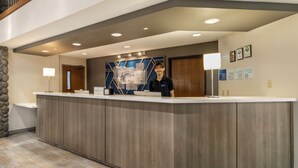 A reception desk with a modern design, a stone accent wall, and a wooden floor.