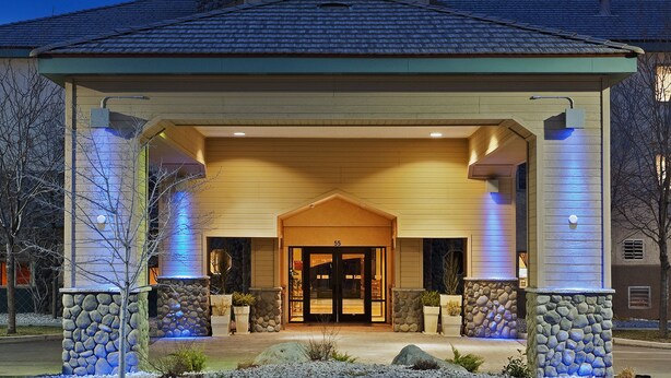 A Holiday Inn Express building with a stone facade, a covered entrance, and a sign above the entrance.