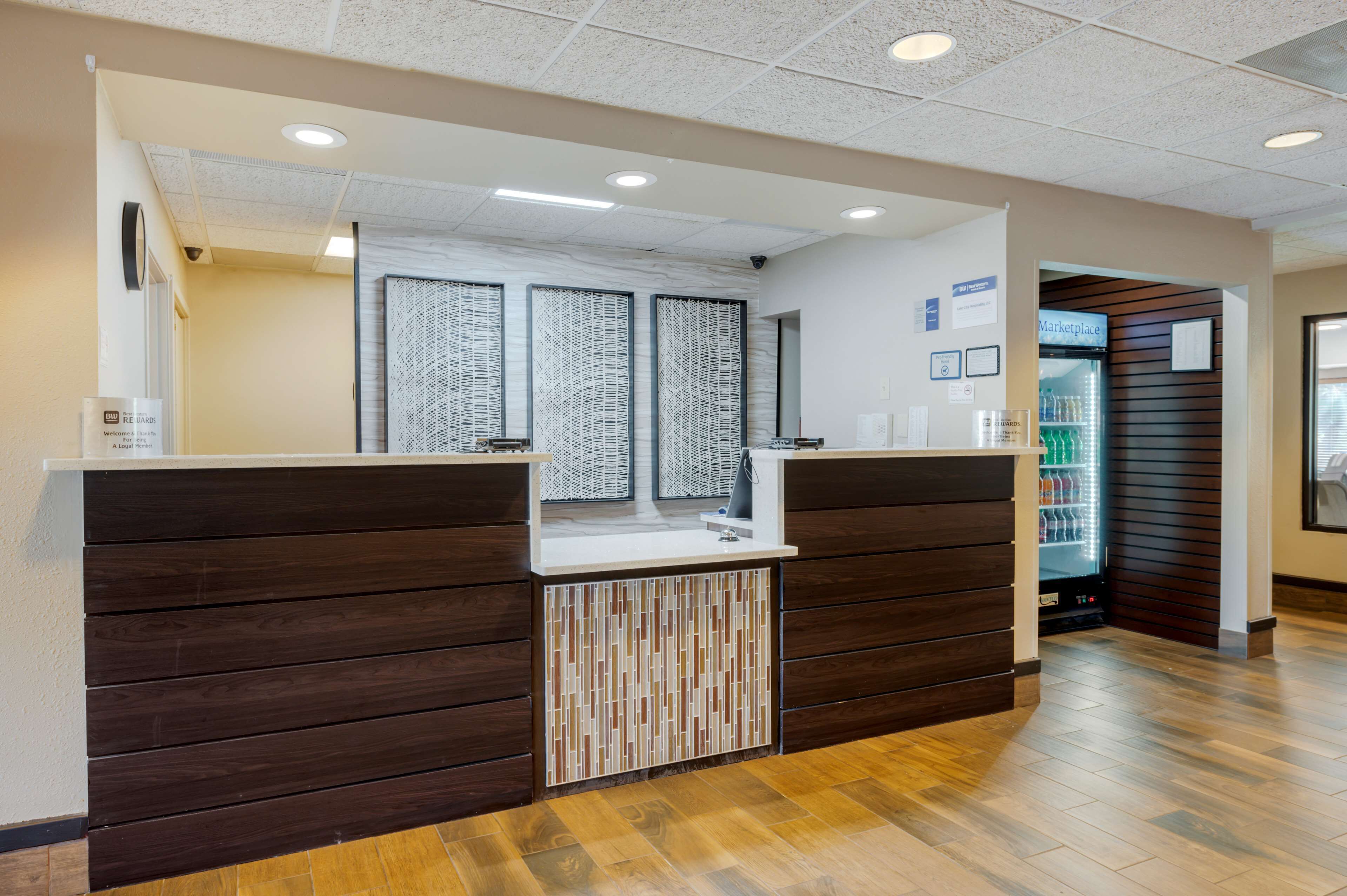 A reception desk with a modern design, a counter, and a wall-mounted information board.