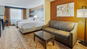 A hotel room with two beds, a sofa, a coffee table, and a large abstract painting on the wall. - Best Western Plus Warsaw (Warsaw)