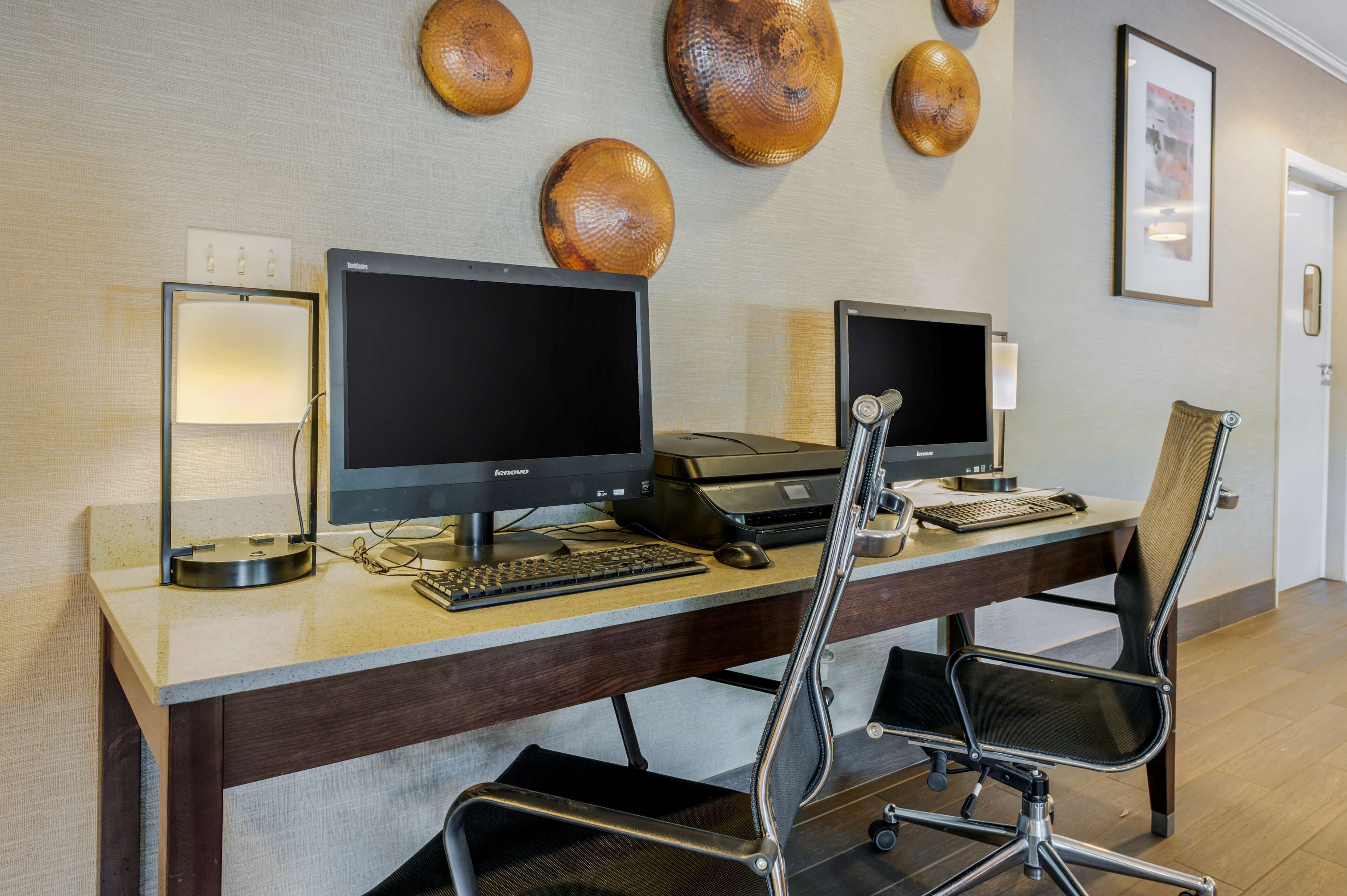 A workspace with two monitors, a keyboard, and a mouse on a desk.