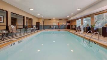 A swimming pool with lounge chairs and a changing room.
