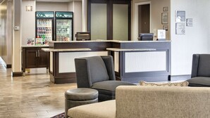 A hotel lobby with seating, a reception desk, and a beverage refrigerator. - Homewood Suites by Hilton Mobile Airport-University Area (Mobile)