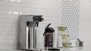 A coffee machine, a water dispenser, and a coffee grinder on a kitchen counter. - Motel 6 Prattville, AL (Prattville)