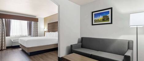 Ein Hotelzimmer mit Bett, einer Couch, einem kleinen Tisch und einem Bild an der Wand.