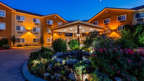 Un hôtel doté d’un espace extérieur couvert, d’un jardin agrémenté d’un élément aquatique et de nombreuses fenêtres.