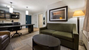 Een moderne woonkamer met een bank, een salontafel en een eethoek met een tafel en stoelen.