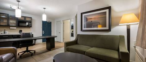 A modern living room with a sofa, a coffee table, and a dining area with a table and chairs.