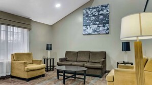 A living room with a sofa, two armchairs, a coffee table, and two side tables. - Sleep Inn near I-80 and I-94 (Lansing)
