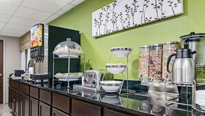 A buffet counter with a coffee machine, toaster, and various food containers. - Sleep Inn near I-80 and I-94 (Lansing)