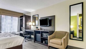A hotel room with a bed, desk, chair, TV, and large mirror. - Sleep Inn near I-80 and I-94 (Lansing)