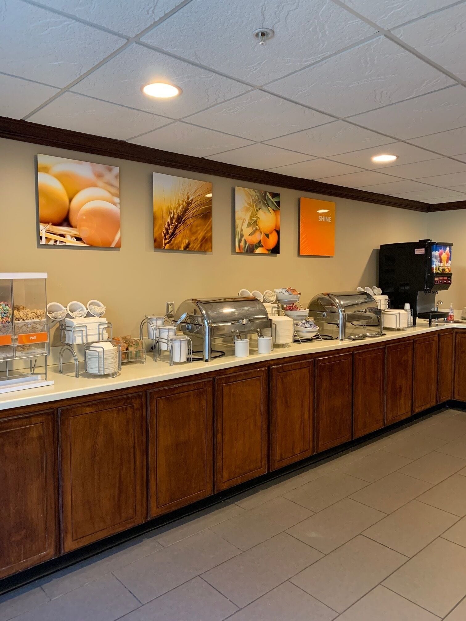 Ein Frühstücksbuffet mit verschiedenen Speisen, einer Kaffeemaschine und einem Fernsehbildschirm, der ein Programm zeigt.