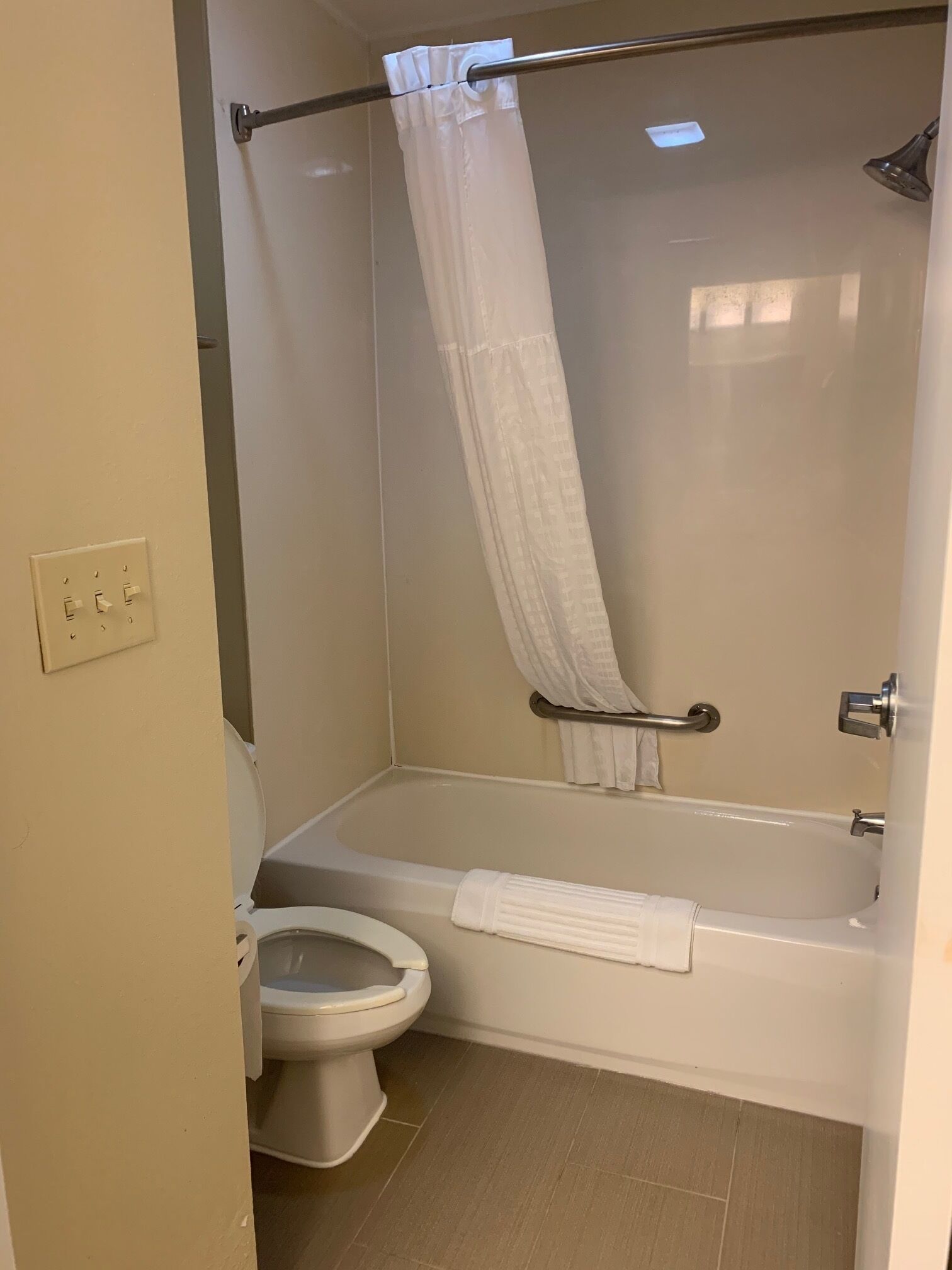 A bathroom with a bathtub, toilet, and shower curtain.