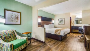A hotel room with a bed, a sofa, a desk, and a chair. - Quality Inn & Suites Lake City (Lake City)