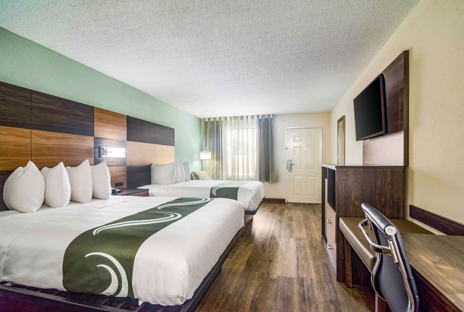 Premium bedding, desk, laptop workspace, blackout drapes