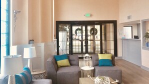 A spacious lobby with a chandelier, sofas, a reception desk, and a large window. - Quality Inn & Suites Lake City (Lake City)