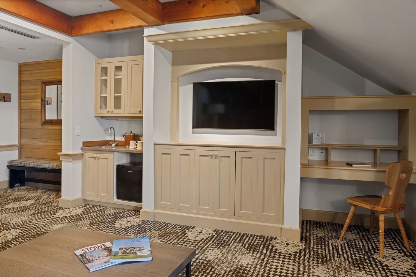 A compact kitchen with built-in cabinets, a large window, and a dining area with a table and chairs.