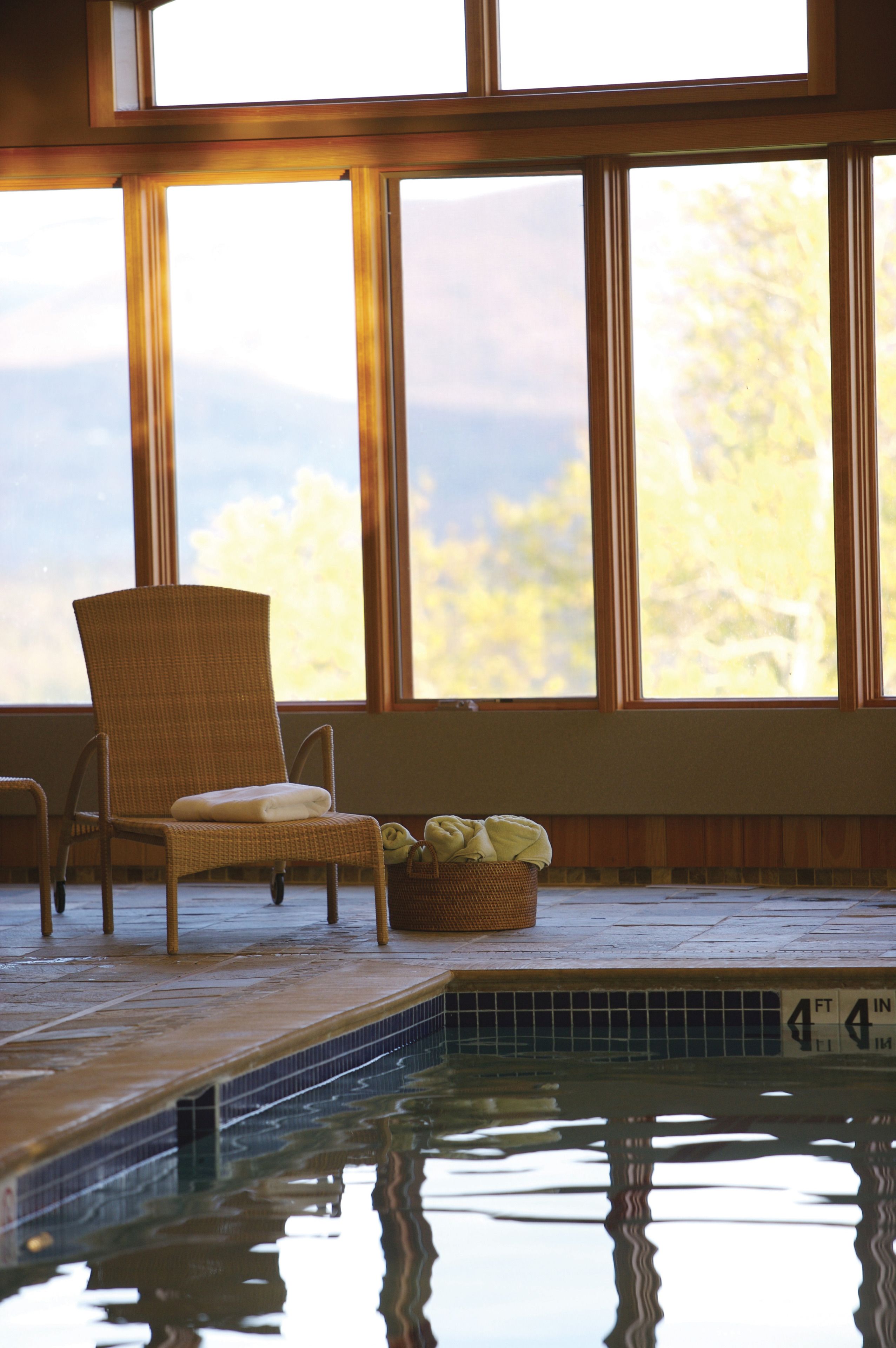 A pool area with a chair and a basket.